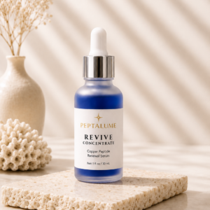 Peptalume Revive Concentrate Copper Peptide Renewal Serum in frosted glass bottle with blue serum on modern neutral skincare display