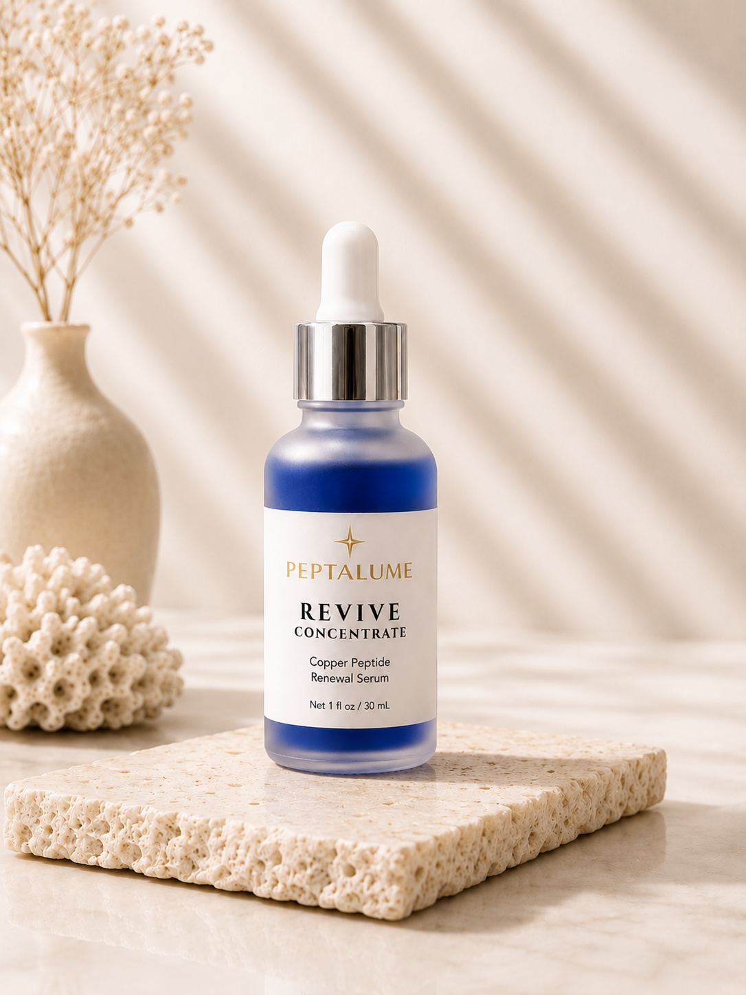 Peptalume Revive Concentrate Copper Peptide Renewal Serum Peptalume Revive Concentrate Copper Peptide Renewal Serum in frosted glass bottle with blue serum on modern neutral skincare display